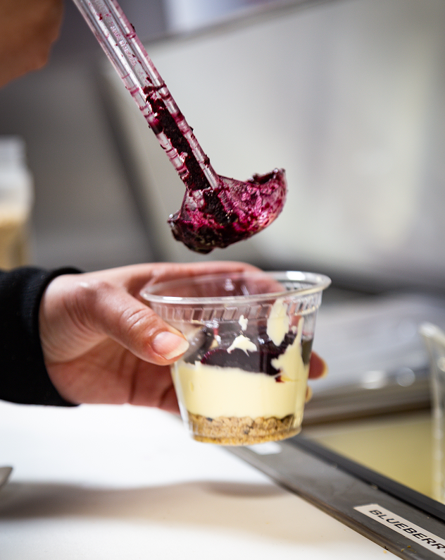 Blueberry purée being ladled into a parfait cup