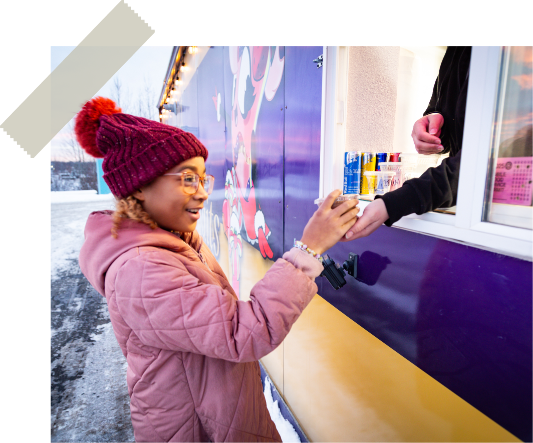 A guest smiling as she receives a pudding parfait at the C&D window