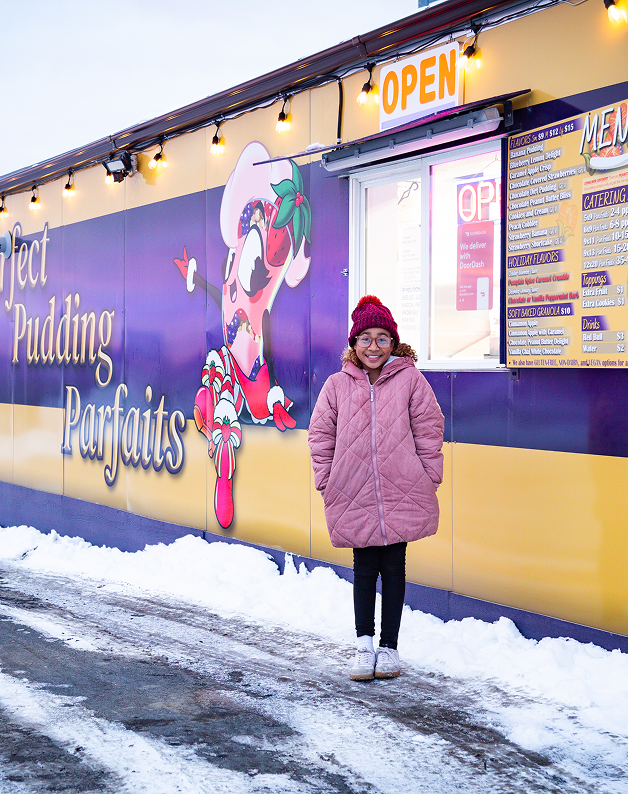 A guest outside the purple and gold C&D Perfect Pudding Parfaits shop